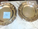 deux assiettes en argent posées sur une table, avec une étiquette de prix