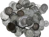 une pile de vieilles pièces d'argent sur une surface blanche
