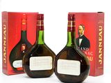 two bottles of brandy sitting next to each other in front of a box