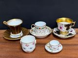 a table topped with cups and saucers on top of a wooden table