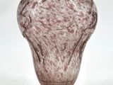 un vase en verre posé sur une surface blanche