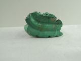 an image of a piece of green stone sitting on a white surface