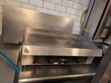 plan de travail en acier inoxydable dans une cuisine professionnelle, sur lequel est fixé un tuyau