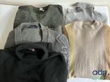 four sweaters are laid out on a white surface with a logo on the back