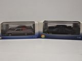 deux boîtes contenant chacune une voiture noire et une voiture rouge