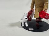 a figurine of a man with a suitcase and a dog