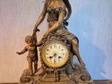 une statue de femme assise au sommet d'une horloge