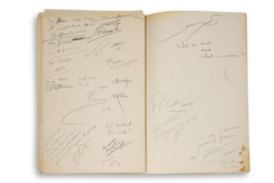 un livre ouvert, couvert d'écriture, posé sur une surface blanche