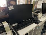 a desk with a computer monitor and keyboard on it