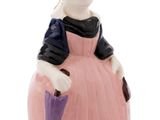 une figurine représentant une femme vêtue d'une robe rose et tenant un parapluie