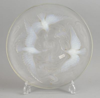deux assiettes en verre blanc ornées d'oiseaux, posées sur un présentoir