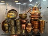 a glass display case with a lot of copper pots and pans