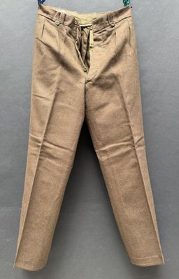 un pantalon suspendu à un cintre accroché au mur