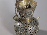 a silver vase with a chain around it on a table