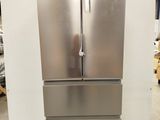 a picture of a stainless steel refrigerator in a warehouse