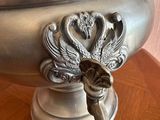 a silver vase on a table with a key in it