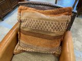 a brown chair with a pillow on it in a room