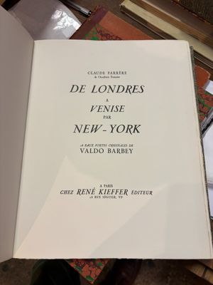 un livre ouvert posé sur une table à côté d'une pile de livres
