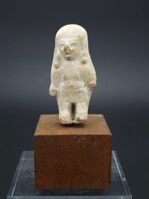 une image représentant une statue d'une personne debout sur un bloc de bois