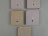 four different colors of light switch covers on a wall