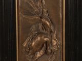 an image of a bronze plaque depicting a woman and a bird