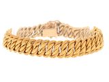 gros plan d'un bracelet en or sur fond blanc