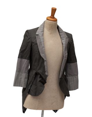 une veste sur un mannequin, avec un torse de mannequin blanc en arrière-plan