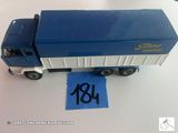 un petit camion jouet bleu avec une étiquette bleue dessus