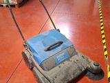 an image of a floor scruber sitting on the floor in a warehouse