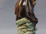 a figurine of a woman sitting on a rock