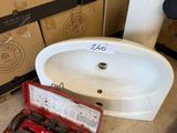 un évier et des outils dans une caisse posée par terre