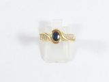 Gros plan sur une bague en or ornée d'une pierre bleue