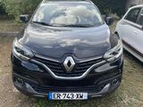 une voiture noire garée à côté d'une voiture blanche dans une cour