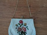 white purse with flowers on it hanging on a wooden wall