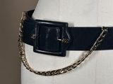 a mannequin torso with a black belt and a gold chain