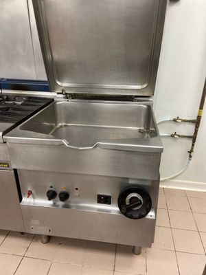 a large stainless steel stove in a kitchen with two burners