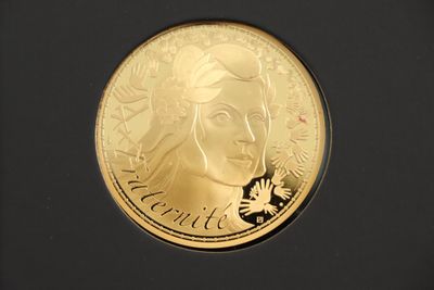 the gold coin has a woman ' s face on it