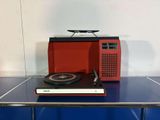 a red and black radio sitting on top of a blue table