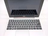 a silver laptop with a black keyboard on a white table