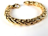 a close up of a gold bracelet on a white surface