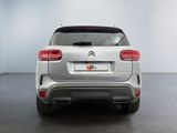 the rear end of a silver suv parked in a white room