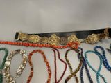 a lot of necklaces and bracelets that are on a table