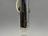un vase en verre muni d'une anse, posé sur un socle transparent