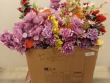 une boîte en carton contenant un bouquet de fleurs, posée sur une palette