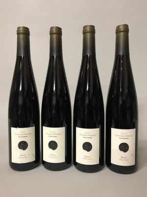 quatre bouteilles de vin sont alignées sur une table