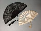 un éventail en dentelle noire et un autre éventail en dentelle noire posés sur une table