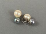 pair of pearl and silver earrings on a gray surface