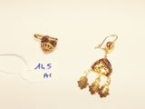 two gold earrings and a gold ring on a white surface