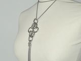 necklace with a chain and a tassel on a mannequin torso