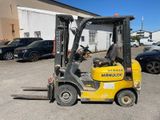 a yellow forklift truck parked in a parking lot
